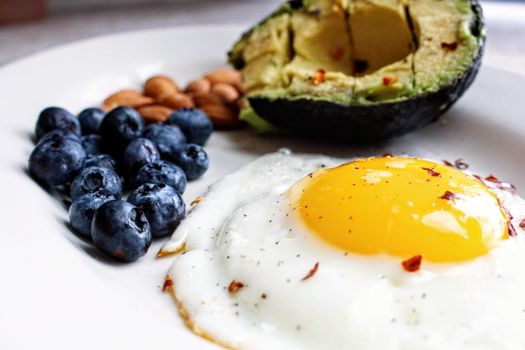 Gezonde keto maaltijd met avocado, zalm en groenten op tafel in lifestyle setting
